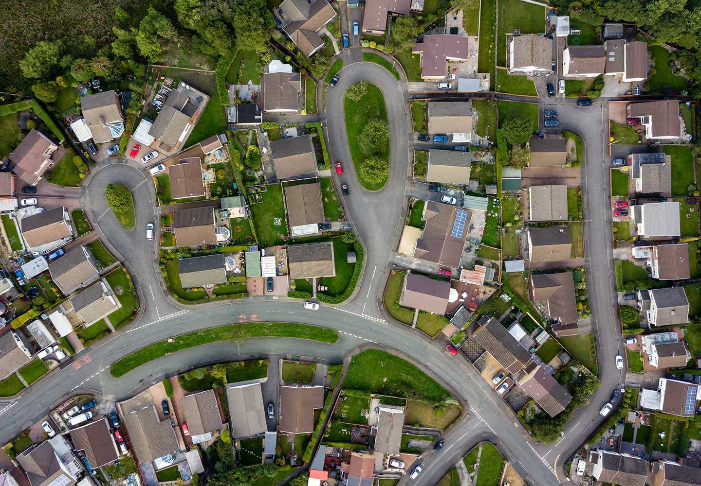 Top down aerial view of urban houses and streets in a residential area.