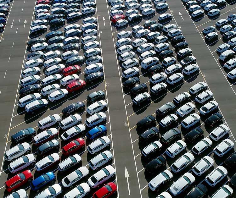 Aerial photo of cars parked in giant lot awaiting delivery.